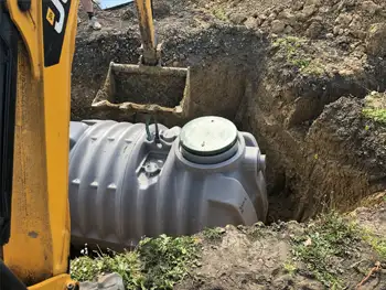 Digger Carefully Positioning the Septic Tank for Installation