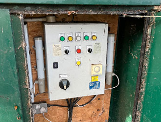 Outdoor pump control board inspected for electrical and safety faults before cleaning.