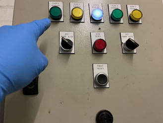 Engineer testing start/stop controls and alarm functions.